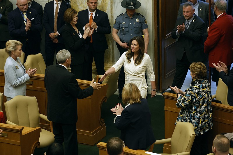 Arkansas Gov. Sarah Huckabee Sanders (center) is greeted by Rep. Jack Ladyman, R-Jonesboro, and the rest of the Legislature as she enters the House chamber of the state Capitol in this April 10, 2024, file photo. (Arkansas Democrat-Gazette/Thomas Metthe)